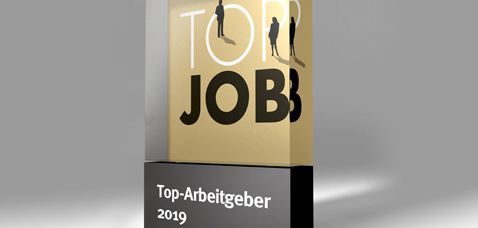 Top Job Award, oberer Teil aus Glas mit goldenem Hintergrund darauf schwarz/weiße Schrift "TOP JOB" unterer Teil auf schwarzen Stein mit weißer Schrift "Top-Arbeitgeber 2019"
