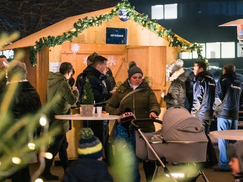 Weihnachtsmarkt Glühweinstand viele Menschen Weihnachtsbeleuchtung 