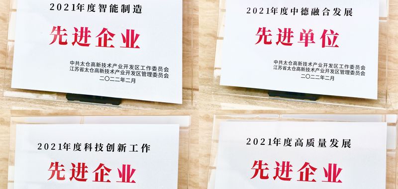 vier weiße Blätter mit roter asiatischer Schrift liegen auf einem Tisch